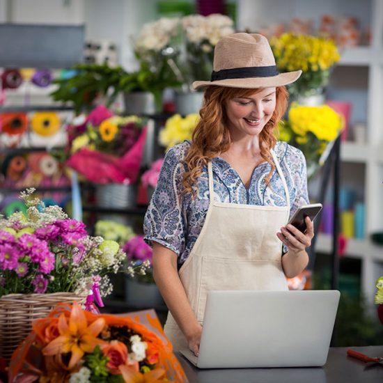 A business owner posting on social media with her phone